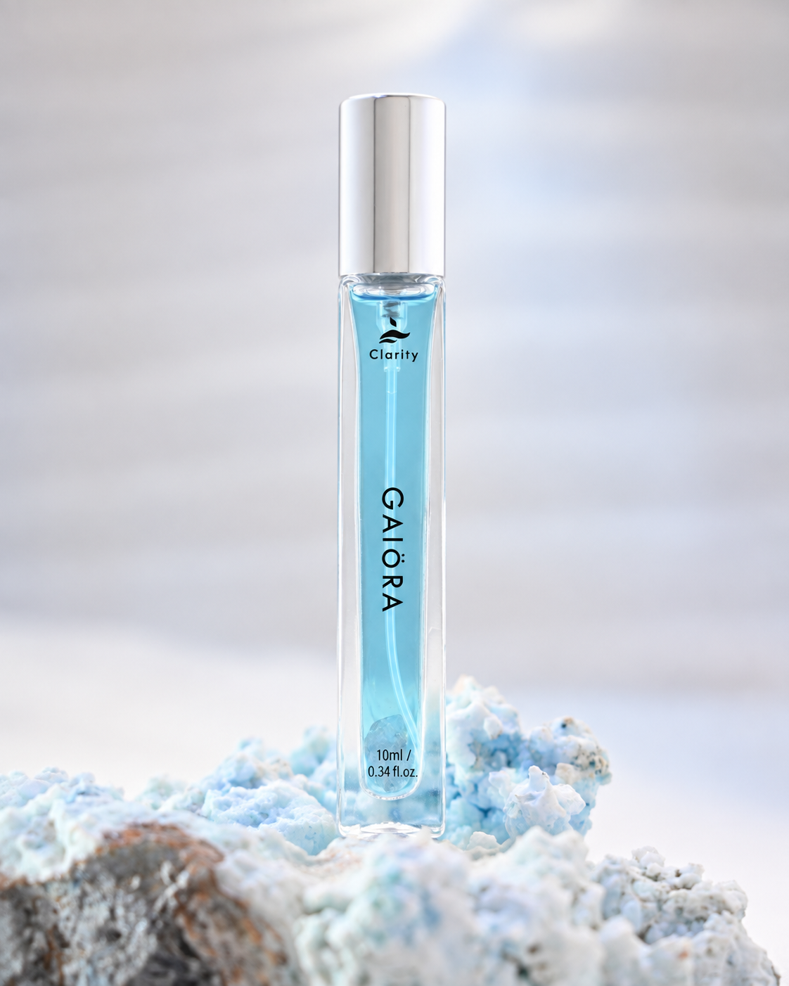 A clear rectangular roller bottle filled with light blue liquid, featuring a silver cap and the brand name 'Clarity' and product name 'GAIORA' printed on the front. The bottle is styled on a textured, icy blue and white mineral-like surface against a soft, out-of-focus light gray background.