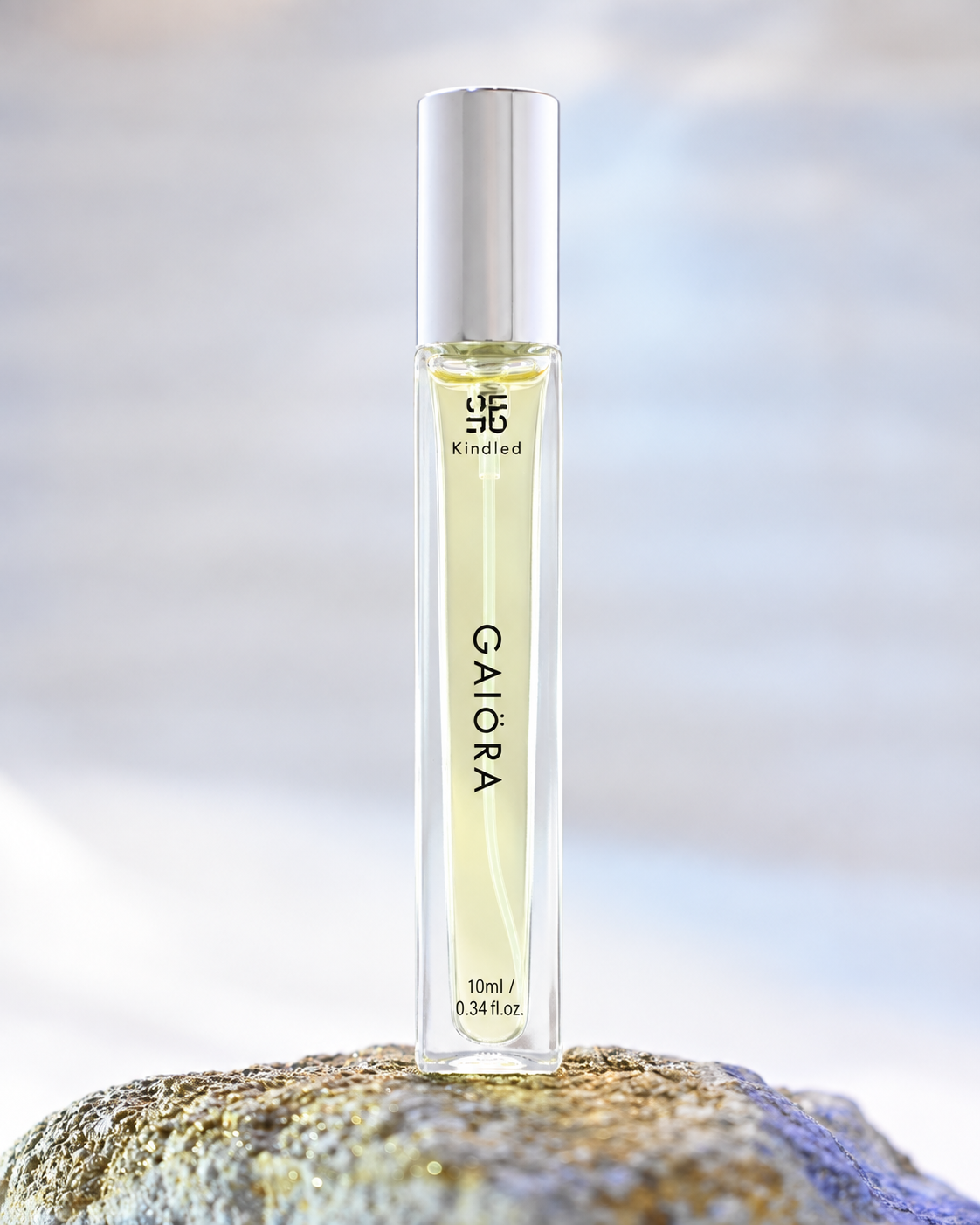 A clear rectangular perfume or fragrance roller bottle with pale yellow liquid, a silver cap, and black text reading 'KINDLED GAIORA' and '10ml / 0.34 fl.